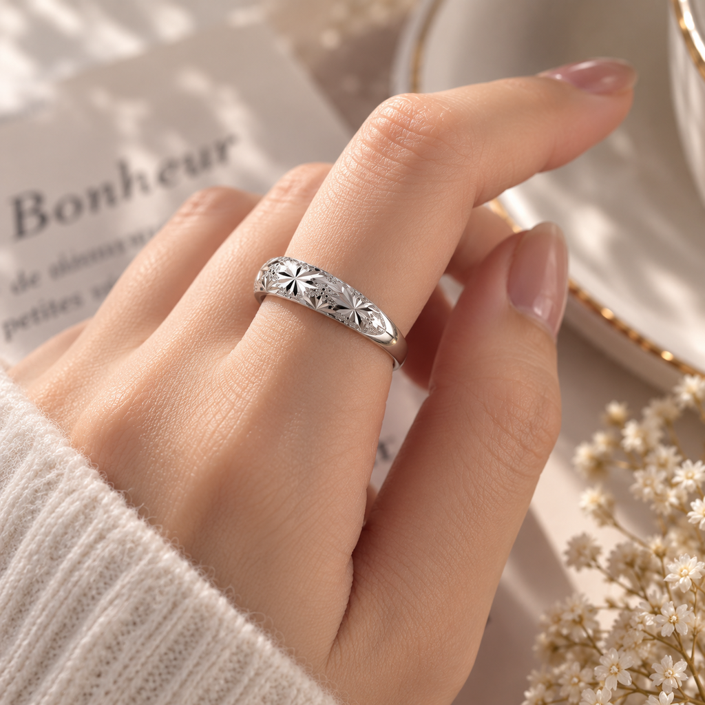 Bague argentée à motif floral portée au doigt, vue du décor et des proportions