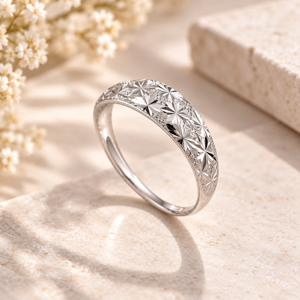 Bague argentée dressée, gros plan sur le motif floral étoilé et les détails gravés