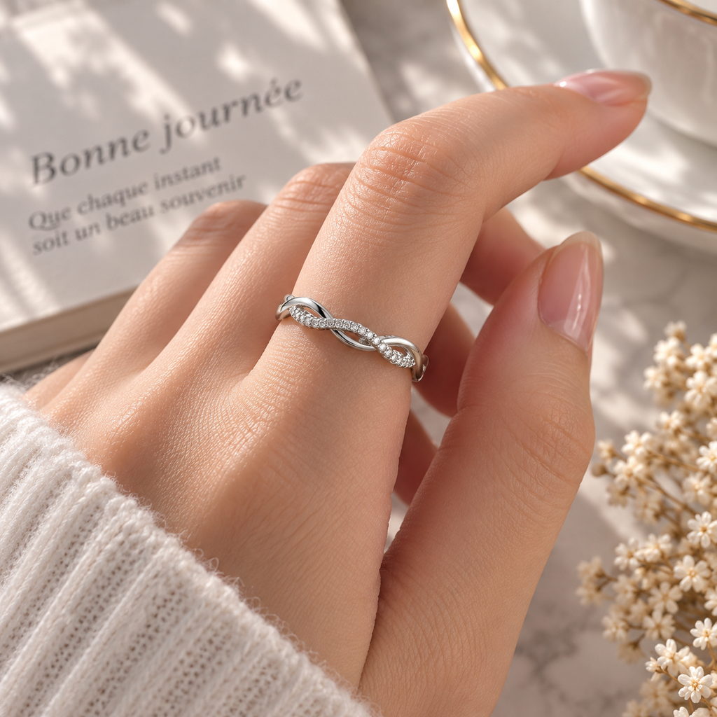 Bague fine argentée entrelacée portée au doigt