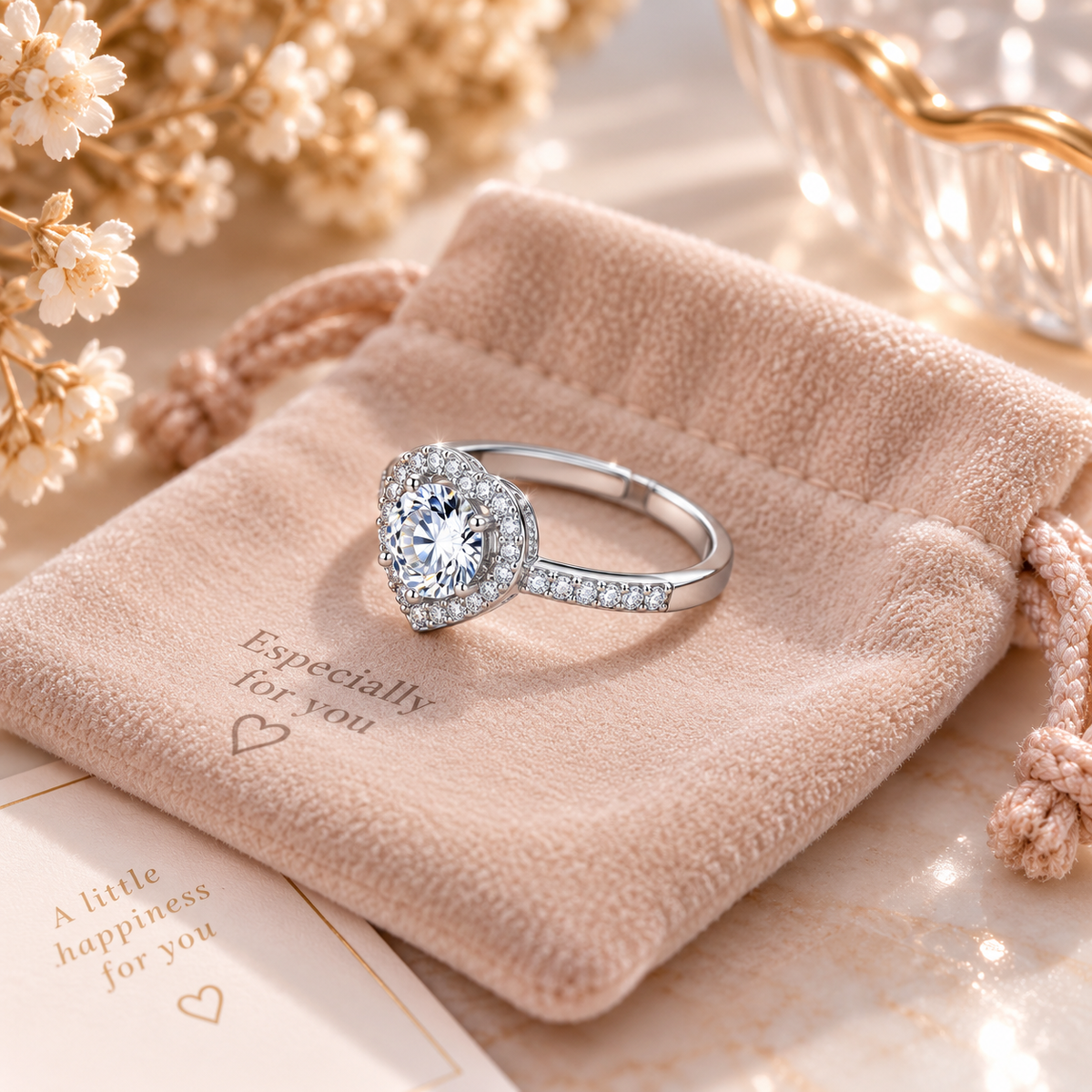 Bague cœur argentée ajustable sur un pochon en velours rose, vue de trois quarts