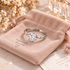 Bague solitaire argentée présentée sur une pochette en velours rose