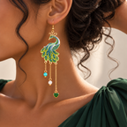 Boucle d’oreille paon à chaînettes et cœur vert portée de profil