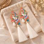 Paire de boucles d’oreilles phénix multicolores sur une pochette en velours