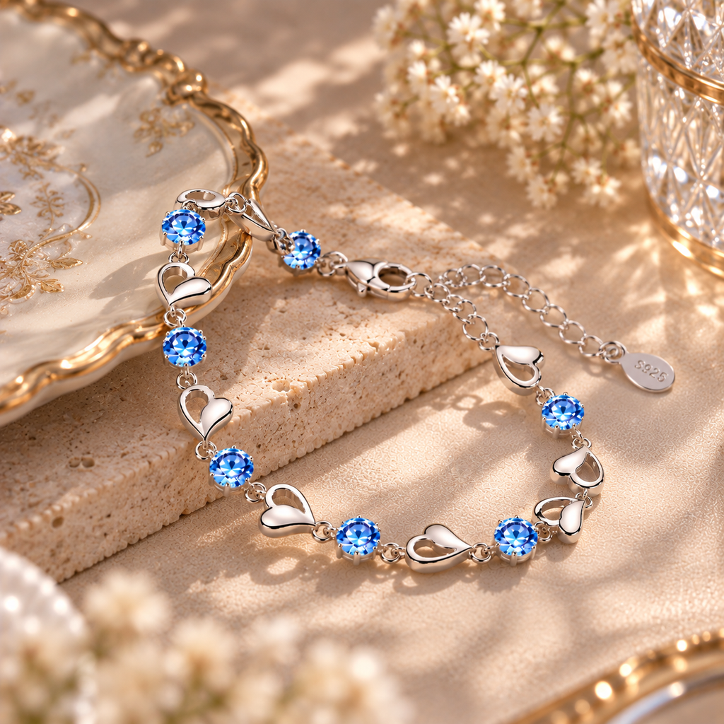 Vue du bracelet argenté à cœurs et pierres bleues avec son fermoir mousqueton