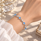 Bracelet à cœurs argentés et pierres bleues porté au poignet