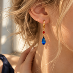 Boucle d’oreille dorée bleue et rouge portée
