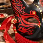 Ornement floral doré et pompon rouge sur le côté du masque de renard noir